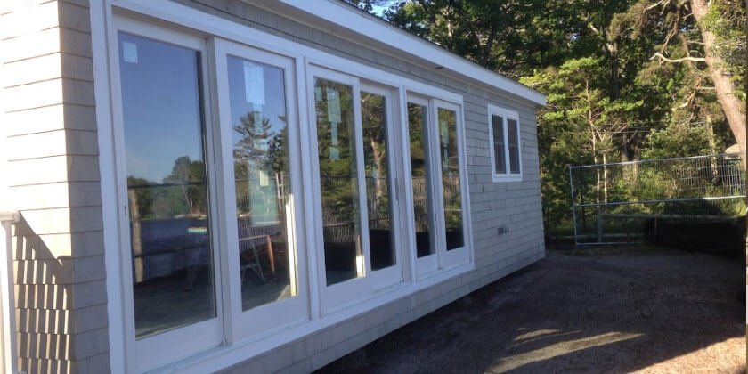 A newly constructed sunroom addition on a house in Malden, CA, with multiple windows and a fenced area to the right.